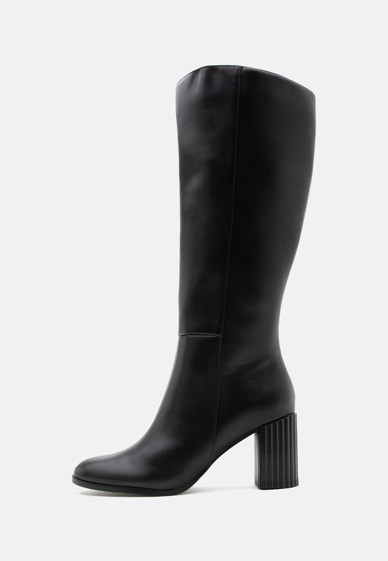 Botte en cuir noire montante jusqu'au genou avec bout arrondi et talon bloc texturé sur un fond clair uni.