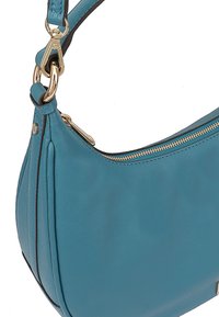 Teal leren handtas met een gebogen vorm, ritsluiting en gouden hardware. Voorzien van een schouderband en subtiele plooien voor textuur.