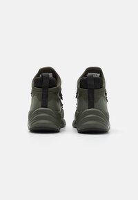 Zapatillas verdes de corte medio con paneles de malla texturizada, una suela acolchada y lengüetas para un fácil calzado. Materiales duraderos con un diseño elegante.