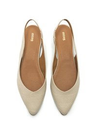 Des chaussures à brides beiges avec une finition texturée, un design à bout pointu et des côtés découpés. Intérieur doux avec semelle brune et marquage subtil.