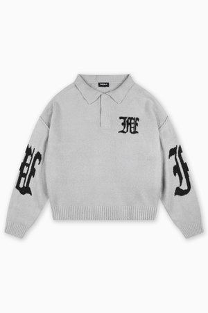 Lys grå strikket genser med krage. Har svarte broderte bokstaver på brystet og ermene, samt ribbet kant nederst og på mansjettene.