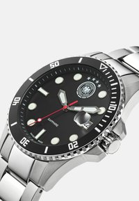 Herrenarmbanduhr mit Edelstahlband, schwarzem Zifferblatt, leuchtenden Markierungen und einem roten Sekundenzeiger; verfügt über ein Saphirglas und eine Datumsfunktion.