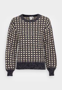 Pull en tricot présentant un motif géométrique noir et crème, col rond, poignets et ourlet côtelés. Texture douce avec une coupe décontractée.