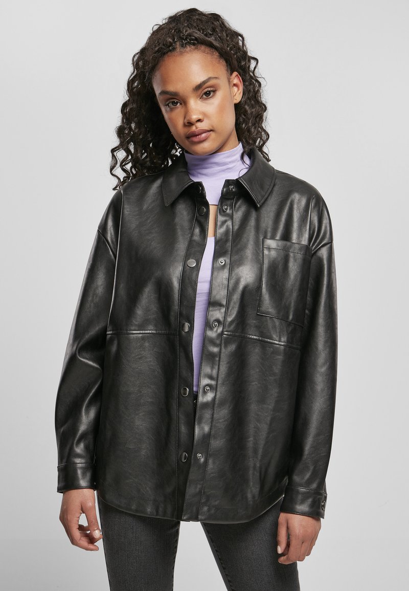 Veste chemise noire en cuir synthétique avec un devant à boutons, une poche poitrine et une coupe décontractée. Texture lisse avec une finition brillante.