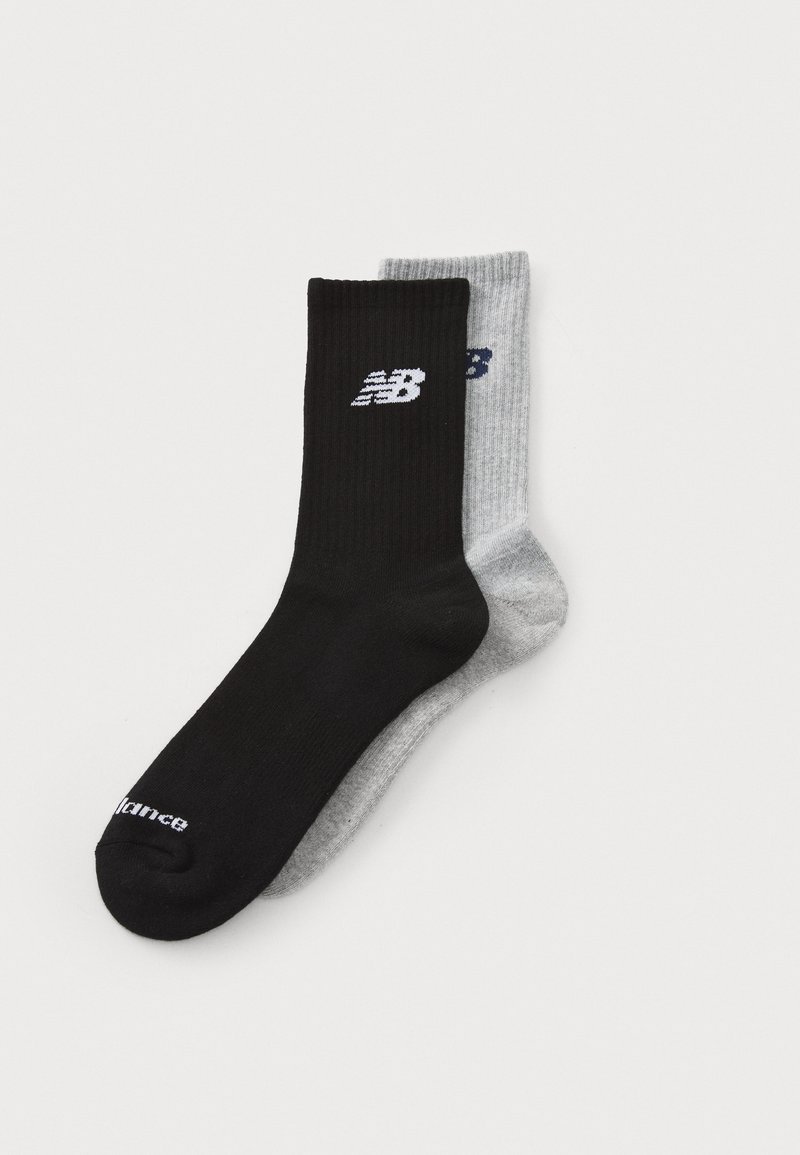 Black and gray ribbed socks featuring the New Balance logo, with a sleek design and smooth texture. Each sock has a contrasting color accent.