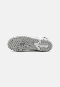 White athletic shoe sole with textured rubber for traction. Features a grey and black pattern on the bottom for grip and durability.