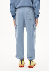 Hellblaue Cargo-Hosen mit elastischen Bündchen, Seitentaschen und einer Gesäßtasche. Aus weichem Stoff gefertigt und im bequemen Schnitt.