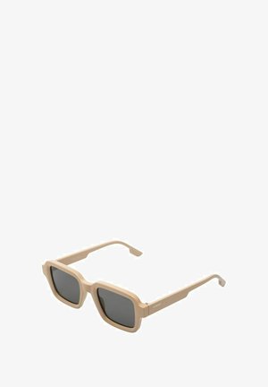Beige vierkante zonnebrillen met donkere lenzen, een dikke rand en opvallende hardware-accenten. Lichtgewicht kunststof constructie.