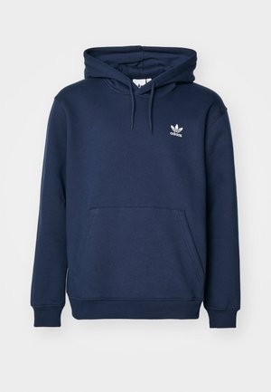 Marineblå hettegenser laget av mykt materiale har en kengurulomme, snorhette, og en liten hvit Adidas-logo på brystet.