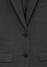 Veste à carreaux gris foncé avec motifs à carreaux noirs et rouges, deux boutons noirs, revers crantés et poches à rabat.