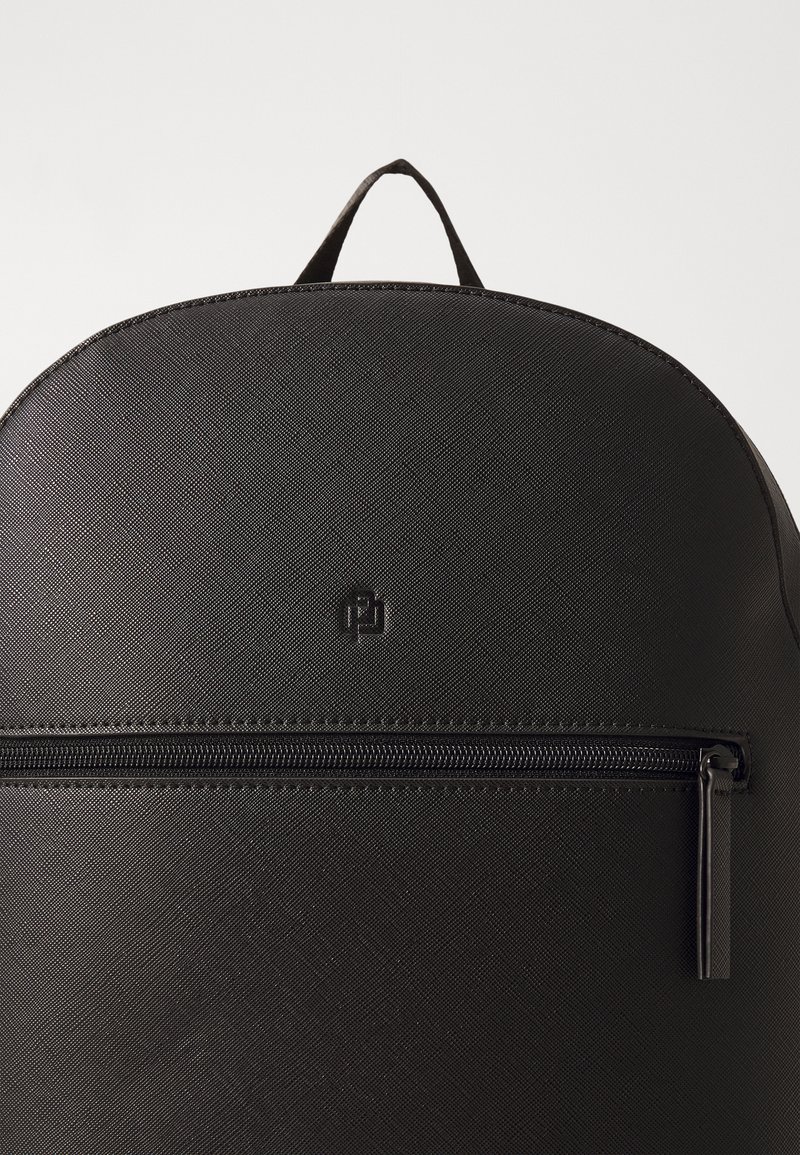 Sac à dos noir en matériau texturé, avec un sommet arrondi, une poche zippée à l'avant et un détail de logo. Durable avec un design simple.