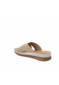 Infradito beige con fasce incrociate, dotati di un design testurizzato e una soletta imbottita. Suola intermedia bianca e suola in gomma marrone.