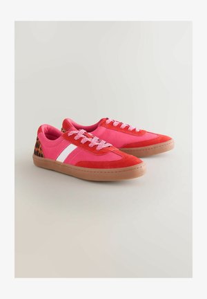 Adidași roșii și roz cu un exterior din suede, având o dungă albă, călcâi cu un model și talpă din cauciuc texturată. Colorat viu, cu șireturi.