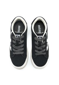 Schwarze Sneakers mit weißen Akzenten, aus Canvas-Material, runde Zehen, flache Sohlen und gemusterte schwarz-weiße Schnürsenkel. Strukturierte Innenseite.