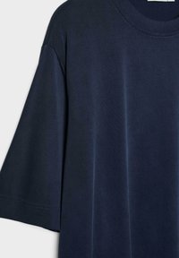 T-shirt bleu marine foncé à manches courtes, col rond et coupe ample, présenté sur un fond clair.