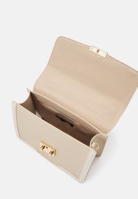 Pochette rectangulaire en cuir beige avec fermeture à tourniquet dorée, rabat ouvert dévoilant un unique compartiment intérieur et une doublure en tissu.