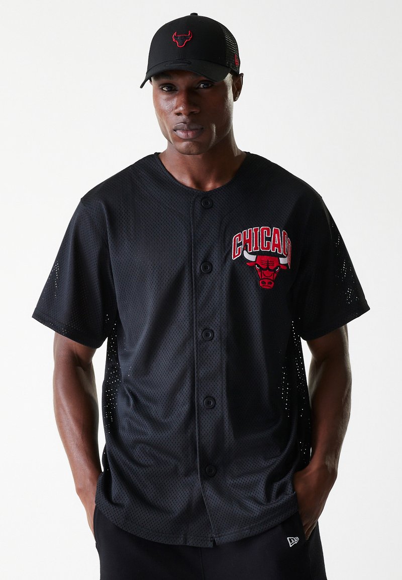 Black mesh baseball jersey with Chicago Bulls logo in red. Features buttons and short sleeves with perforated sides for breathability. Black cap.