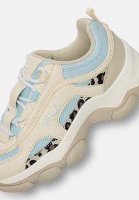 Beżowe buty sportowe z jasnoniebieskimi akcentami, siateczkowymi panelami, detalem w panterkę, białymi sznurowadłami oraz grubymi gumowymi podeszwami z okrągłymi bieżnikami.