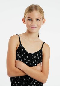 Zwarte camisole met witte sterrenpatronen en tekst. Het heeft dunne banden en een ronde halslijn, gemaakt van een zachte stof.