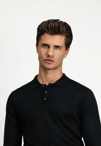 Schwarzes Langarm-Poloshirt aus glattem Stoff, mit einem Kragen und einer Knopfleiste mit drei Knöpfen. Einfaches und tailliertes Design.