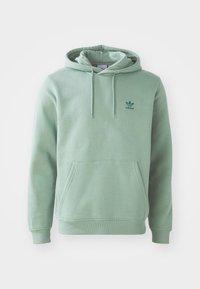 Mintgrön hoodie i bomullsblandning, med en framficka, snörning i huvan och en liten grön Adidas-logotyp på bröstet.
