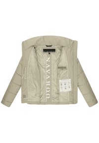 Beige pufferjack met gestikte secties, met een logo aan de binnenkant, witte accenten en meerdere onderhoudslabels. Open voorkant zonder capuchon.
