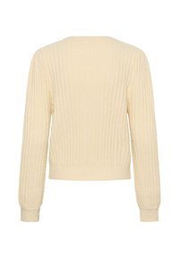 Krēmkrāsas džemperis, ribota tekstūra, garas piedurknes, apaļa kakla izgriezums, pieguļoši aproces un apakšmala, maigs materiāls, attēlots aizmugures skats.