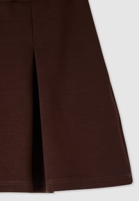 Gonna plissettata marrone realizzata in tessuto elasticizzato, con cuciture pulite e pieghe nette, texture morbida e finiture sartoriali.