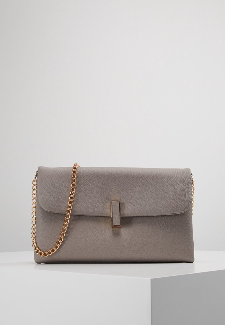 Šedá kožená kabelka s překlopným designem, zlatým řetízkovým popruhem a obdélníkovým kovovým akcentem na přední straně. Texturovaný povrch.