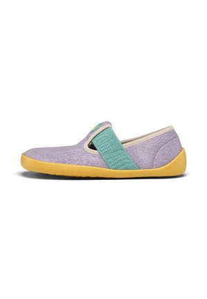 Lawendowy but typu slip-on z żółtą podeszwą i szerokim turkusowym elastycznym paskiem na wierzchu, wykonany z miękkiej, teksturowanej tkaniny.