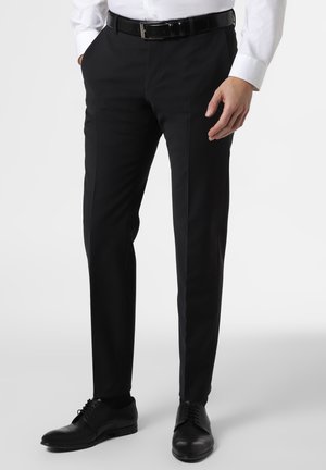 Pantaloni neri in tessuto morbido, con una vestibilità su misura e dettagli sulla piega. Abbinati a scarpe nere in pelle e una cintura nera.