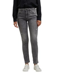 Fatos de ganga cinza, skinny, com detalhes rasgados, cintura alta e estilo de cinco bolsos, combinados com ténis brancos e uma camisa preta.