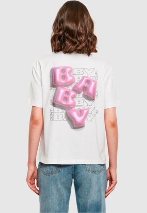 T-shirt blanc à manches courtes avec de grandes lettres rose en forme de ballon épelant "BABY" au dos, avec un superposé de texte gris.