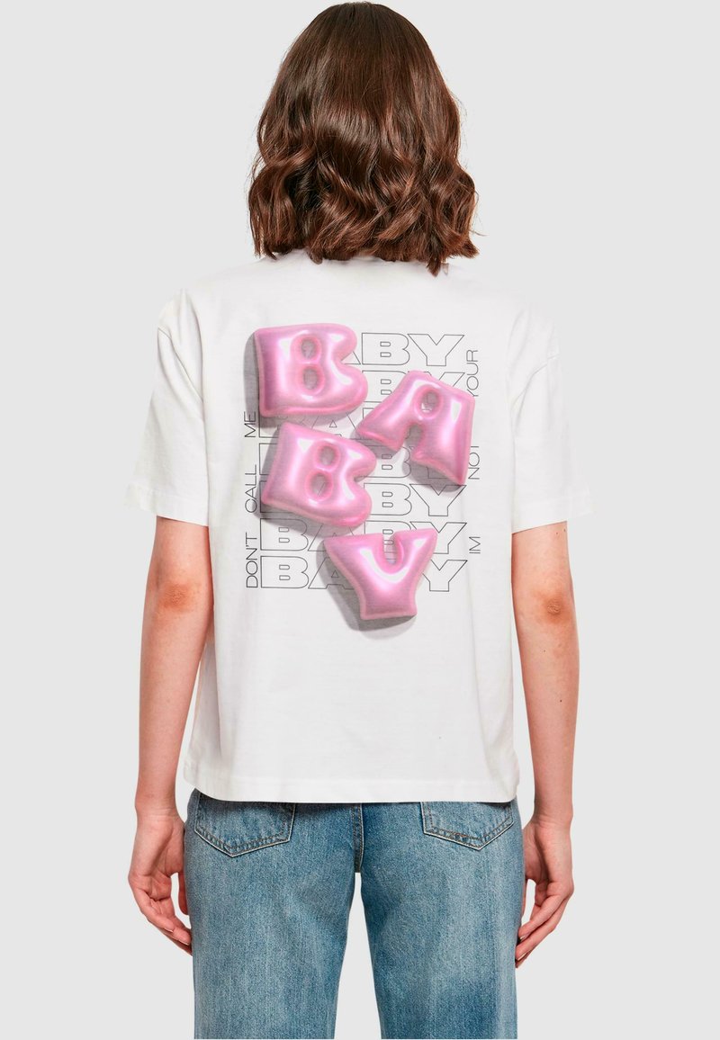 Hvid t-shirt med korte ærmer, der har store pink ballon-lignende bogstaver, som staver "BABY" på ryggen, med en grå tekstoverlay.