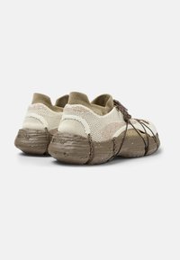 Lightweight, beige mesh sneakers with a textured brown rubber sole, featuring decorative brown laces and a knit collar for comfort.