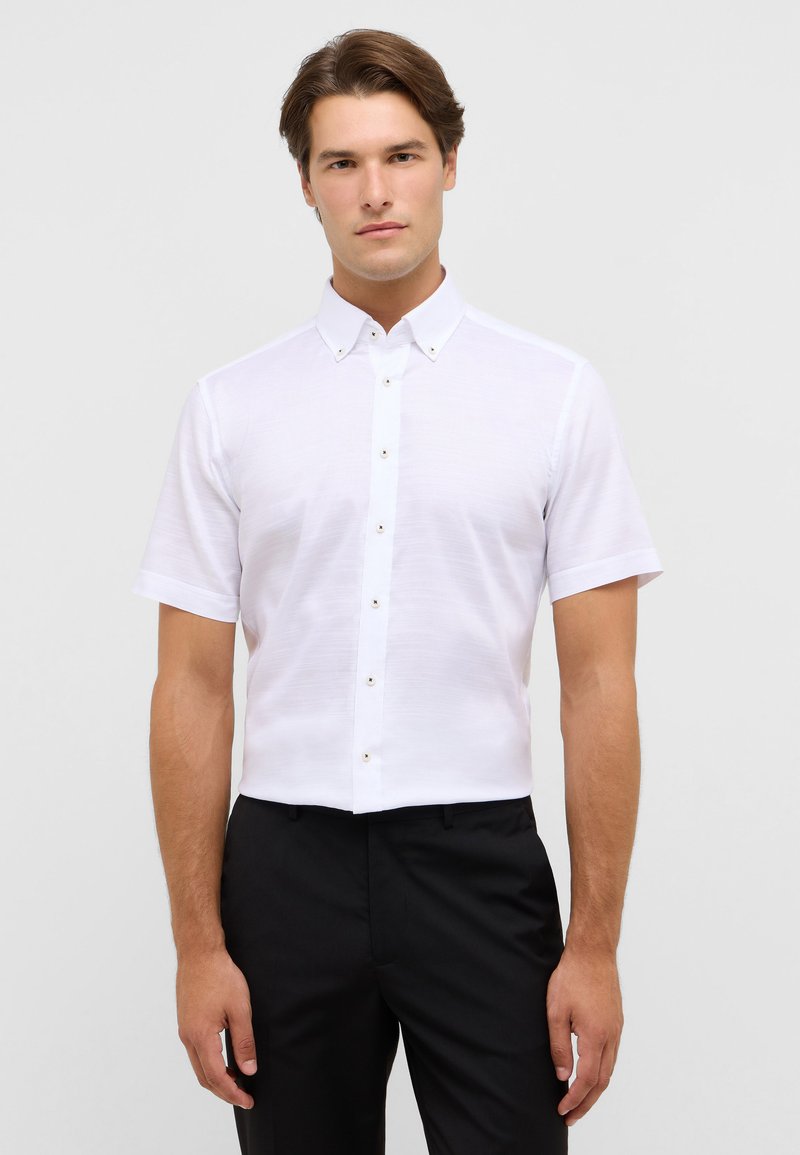 Witte korte mouw shirt met een button-down kraag, voorzien van een frisse textuur en een knoopsluiting aan de voorkant, gecombineerd met zwarte broek.