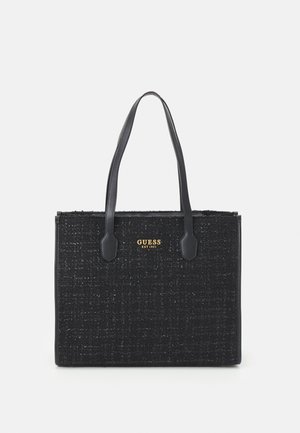 Zwarte getextureerde Guess tote tas met twee lange handvatten en goudkleurig merklogo "GUESS EST 1981" op het voorste midden.