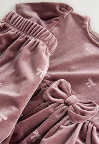 Lila Samtkleid mit gerafften Ärmeln und Taillenband, das mit einer großen Schleifenakzent und kleinen Schleifenmustern versehen ist. Glatte Textur.