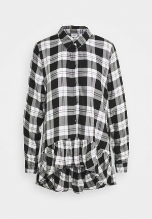 Camicia a scacchi bianca e nera con colletto, chiusura con bottoni sul davanti, maniche lunghe e fondo arricciato in vita.