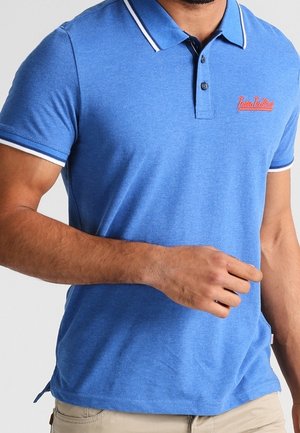 Blaues Poloshirt mit slim Fit, kontrastierenden weißen Streifen am Kragen und an den Ärmeln sowie einem roten gestickten Logo auf der Brust.