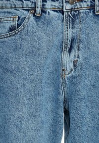Light blue denim jeans with a classic five-pocket design, featuring contrasting orange stitching and a standard button closure at the waist.