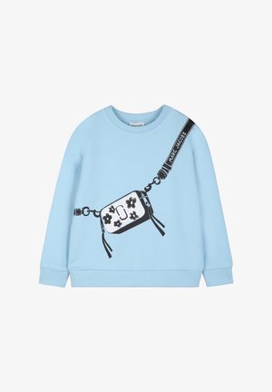 Sweat-shirt bleu clair avec un sac bandoulière noir et blanc à motif floral imprimé, avec une sangle "Marc Jacobs" en détail sur le devant.