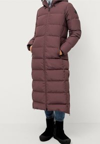 Langer Daunenmantel in dunklem Burgunderrot, mit einem Reißverschluss vorne, Kapuze und zwei Seitentaschen. Hergestellt aus einem gesteppten, isolierten Material.