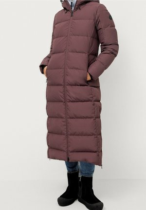 Lange pufferjas in donker bordeaux, met een ritssluiting aan de voorkant, een capuchon en twee zijzakken. Gemaakt van een gewatteerd, geïsoleerd materiaal.