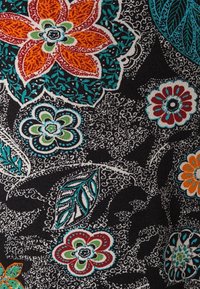 Patroonstof met grote kleurrijke bloemen in oranje, rood, blauw en groen op een zwarte achtergrond met golvende witte details en bladeren.
