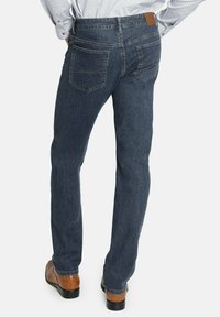 Jeans de mezclilla azul oscuro con corte recto, que presentan dos bolsillos traseros y una etiqueta de cuero marrón en la cintura. Textura suave.