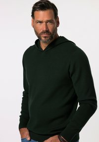 Dunkelgrüner Hoodie aus glattem Strickmaterial, mit einer vorderen Kängurutasche und gerippten Bündchen. Das Design ist lässig und figurbetont.