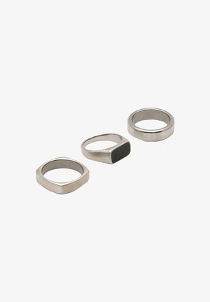 Három fém gyűrű: egy négyzet alakú, egy fekete díszítésű téglalap alakú, és egy kerek, mindegyik matt ezüst színű és sima felületű.