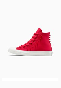 Sneaker alte di un brillante colore rosso, con suole in gomma bianca, caratterizzate da punte testurizzate lungo il lato e una parte superiore in tela con design con lacci.