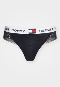 Zwarte stringonderbroek met kanten zijpanelen en een witte tailleband met de merknaam "TOMMY HILFIGER" en logo.